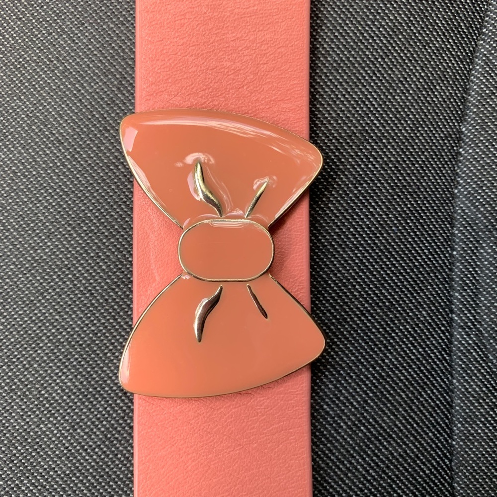 Wide leather band w/ two adj clasp. Muted orange